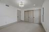 Covered patio featuring large-format porcelain tile flooring and smooth white stucco exterior wall finishes
