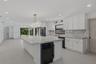 Kitchen featuring white cabinetry, stone-surface countertops, full-height stone backsplash, matte black appliances, and recessed lighting