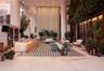 Covered outdoor lounge featuring structural columns, a built-in stone-top bar, recessed ceiling lighting, and tile flooring