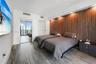 Interior room featuring a wood-slat accent wall, wood-finish flooring, recessed ceiling lighting, and a floor-to-ceiling glass door providing exterior