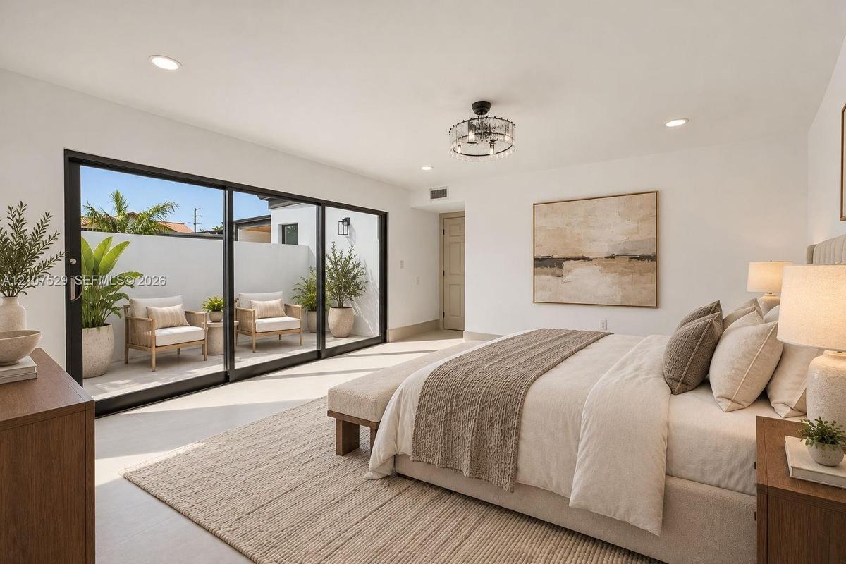 Floor-to-ceiling sliding glass doors with black frames, recessed ceiling lighting, a tiered drum-style chandelier, and light-toned tile flooring