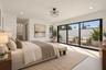 Vaulted ceilings, linear fireplace with a floor-to-ceiling surround, multi-tiered metal chandelier, full-height windows, and large-format tile floorin