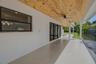 Covered patio featuring a wood-plank ceiling, recessed lighting, matte black ceiling fans, and large-format tile flooring