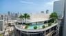 Rooftop swimming pool and spa featuring a concrete deck, manicured landscaping, and panoramic metropolitan backdrop