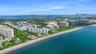 Aerial perspective featuring direct oceanfront access, coastal shoreline, and high-rise residential architecture with proximity to the metropolitan sk