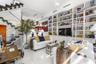 Custom floor-to-ceiling built-in cabinetry with integrated sliding library ladder, floating staircase with glass railings, and white gloss flooring