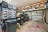 Two-car garage featuring segmented overhead doors and exposed ceiling beams with mounted storage