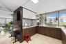 Kitchen featuring two-tone cabinetry with wood-finish lower units and high-gloss upper cabinets, solid-surface countertops, mosaic tile backsplash, an