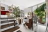 Floor-to-ceiling built-in library shelving with rolling ladder, high-gloss tile flooring, dark wood-finish open staircase, floor-to-ceiling windows wi