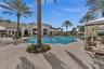 Expansive pool area featuring a large swimming pool, surrounding paver patio, and multiple shade cabanas