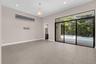 Spacious open-concept room flooded with natural light through expansive sliding glass doors and transom windows
