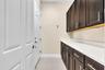 Built-in cabinetry with dark wood-finish doors and brushed nickel hardware, complemented by a white countertop and light wall paint