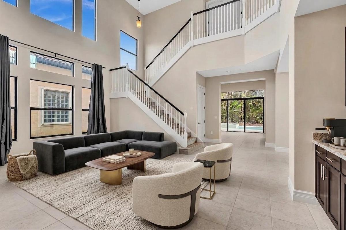 Two-story living area with high ceilings and abundant natural light from upper and lower transom windows