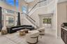 Two-story living area with high ceilings and abundant natural light from upper and lower transom windows