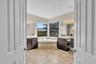 Expansive bathroom featuring a built-in corner soaking tub, dual vanity areas with dark wood cabinetry and light countertops, and large windows