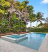 Swimming pool with integrated spa, surrounded by light-toned paving