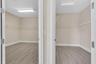 Dual walk-in closets featuring wood-finish flooring, white trim framing, and built-in shelving with rod systems