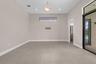 Spacious room featuring neutral tone walls, tile flooring, a horizontal window, recessed lighting, and a contemporary ceiling fixture