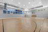 Dedicated indoor sports court featuring professional-grade wood-finish flooring with multiple court markings, recessed ceiling lighting throughout, la