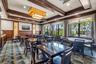 Elegant dining room showcasing coffered ceiling with decorative wood beams, recessed lighting, and a geometric patterned floor