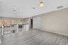 Open concept bonus area featuring light wood-finish flooring, white baseboards, and neutral wall tones