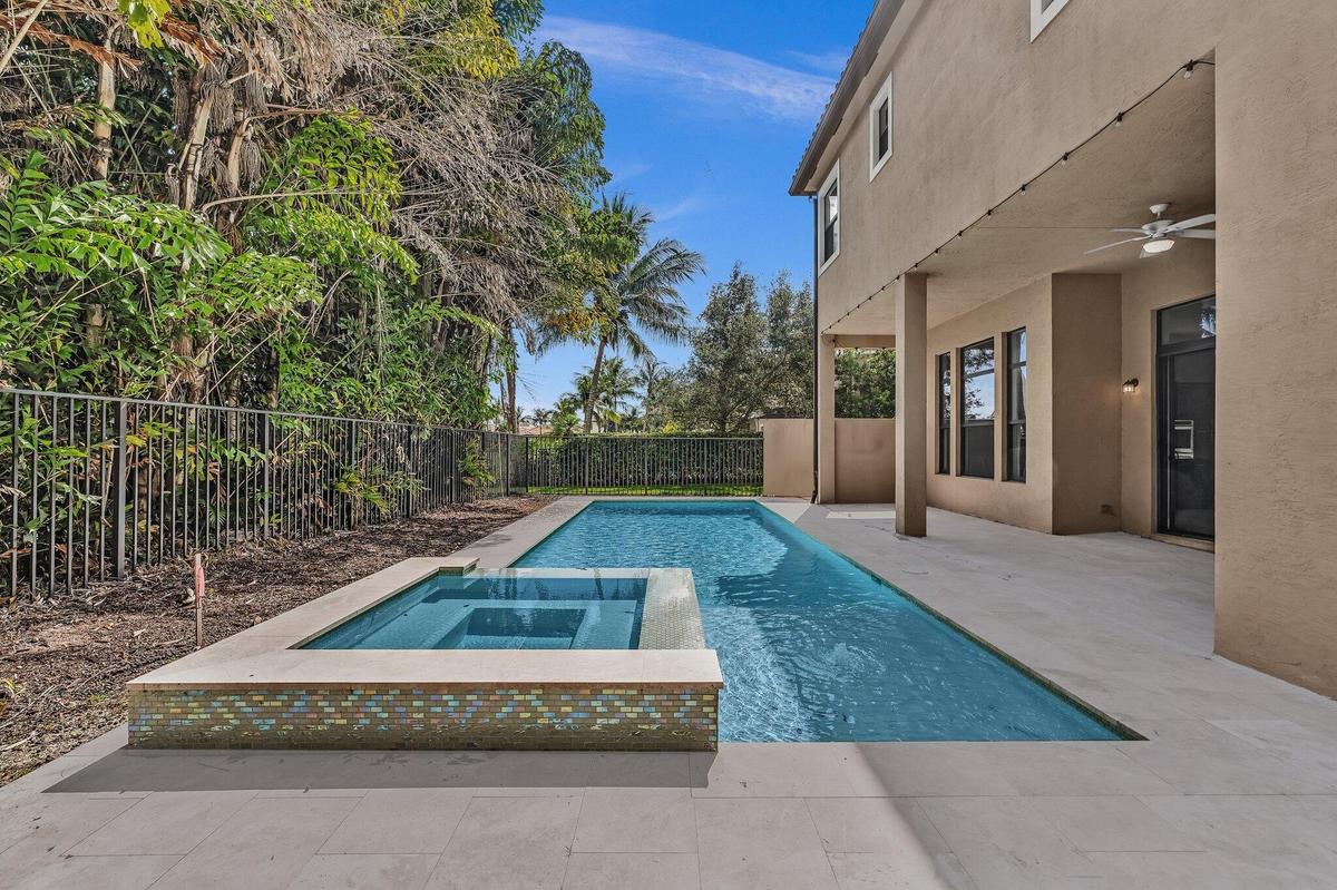 Modern outdoor living space featuring a resort-style saltwater pool with integrated spa, surrounded by expansive concrete decking