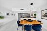 Modern kitchen featuring grey-toned cabinetry, a spacious peninsula, integrated stainless steel appliances, polished stone-finish flooring, and a cont