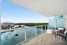 Private balcony featuring wood-finish tile flooring, a glass-panel railing, and frosted privacy partitions