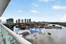 Private balcony featuring glass railings and tile flooring, offering expansive water and cityscape scenery