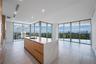 Kitchen featuring a center island with a stone-finish waterfall countertop, integrated cabinetry with wood-finish paneling, recessed lighting, and flo