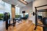 Fitness center featuring floor-to-ceiling windows, wood-finish flooring, high ceilings with recessed lighting, and full-wall mirrors