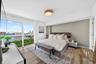 Floor-to-ceiling windows, wood-finish flooring, accent wall, and flush-mount ceiling lighting