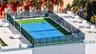 Rooftop tennis court featuring high-perimeter mesh fencing, integrated court lighting, concrete surfacing, and surrounding palm landscaping