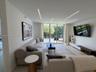 Floor-to-ceiling sliding glass doors, recessed linear architectural lighting, and large-format tile flooring