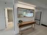 Neutral interior featuring integrated linear lighting, a recessed mirror, and high-gloss cabinetry
