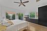 Vaulted ceilings, wood-finish flooring, built-in black cabinetry, ceiling fan, and sliding glass doors