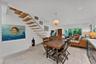 Open-concept area featuring a floating staircase with wood treads, light-toned ceramic tile flooring, recessed lighting, a modern spherical pendant li