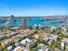 Aerial perspective featuring coastal surroundings, prominent harbor skyline, and multi-family residential development