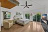 Vaulted ceilings with wood-plank detailing, wood-finish flooring, and sliding glass doors with balcony access