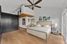 Vaulted ceilings featuring a prominent ceiling fan, wood-finish flooring, floor-to-ceiling dark-finish cabinetry, a built-in ladder, and sliding glass