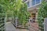 Private courtyard featuring a brick-paver patio, gated metal fencing, and mature landscaping