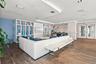 Open-concept common area featuring wood-finish flooring, floor-to-ceiling built-in shelving, recessed ceiling lighting, and double-door glass entry