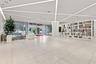 Large-format tile flooring, geometric ceiling lighting, and a floor-to-ceiling built-in open-shelf display unit
