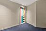 Neutral wall finishes, recessed ceiling lighting, and blue textured carpeting featuring a door with a custom geometric, multi-color graphic finish