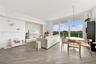 Open-concept living space featuring wood-finish flooring, floor-to-ceiling glass sliding doors, a balcony, and a recessed accent wall with built-in me