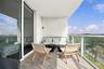 Private balcony featuring wood-finish flooring, glass panel railings, and full-height sliding glass doors