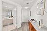 Entryway featuring wood-finish flooring, a wall-mounted mirror, and louvered closet doors