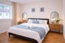 Neutral-toned bedroom featuring wood-finish flooring, a large window, and recessed ceiling lighting