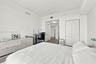 Room featuring wood-finish flooring, white walls, and a closet with double-panel doors