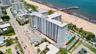 High-rise condominium building featuring direct oceanfront positioning, an outdoor swimming pool, and gated surface parking